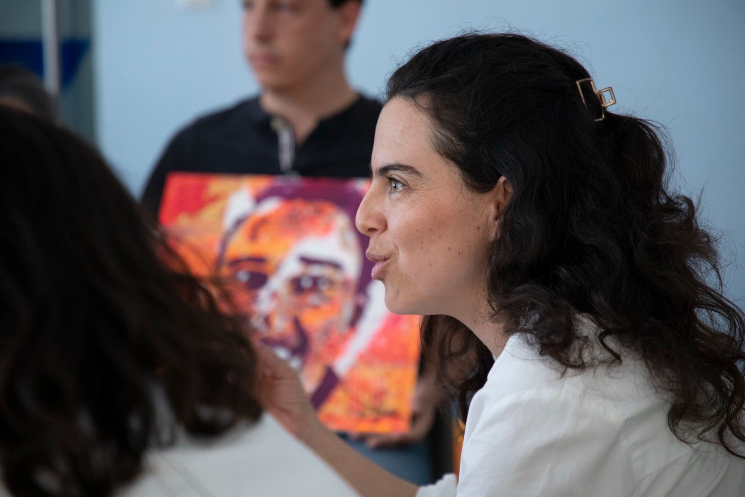 Facilitadora de Mirari junto a un retrato pintado a color